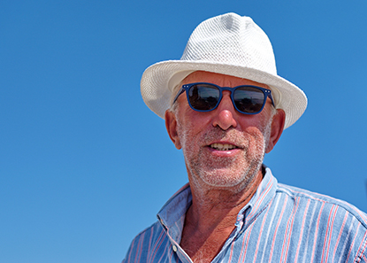 A vibrant, elderly man smiling under the sun